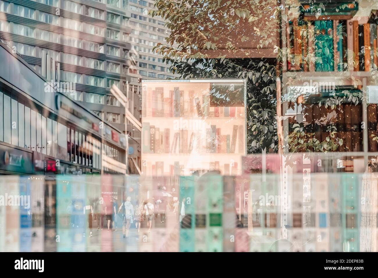 Abstrakt verschwommener Hintergrund von Bücherregalen der Buchhandlung mit bunten Büchern Und Reflexionen im Glasfenster der Bürgersteige mit Nicht erkennbarer p Stockfoto