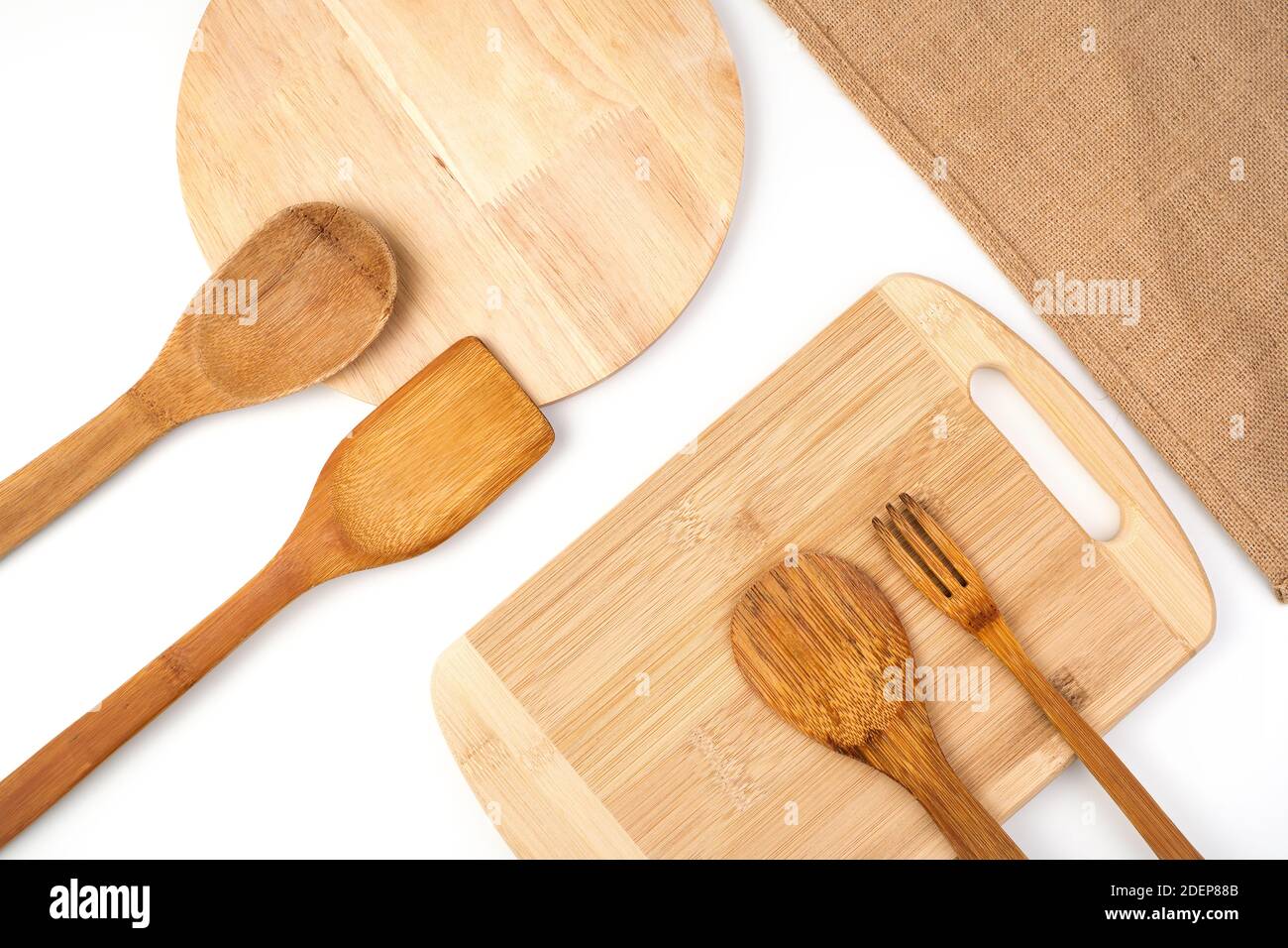 Ein Set aus Holzspateln, Schneidebrettern und einer Leinenserviette auf hellem Hintergrund. Draufsicht mit Platz zum Kopieren. Stockfoto