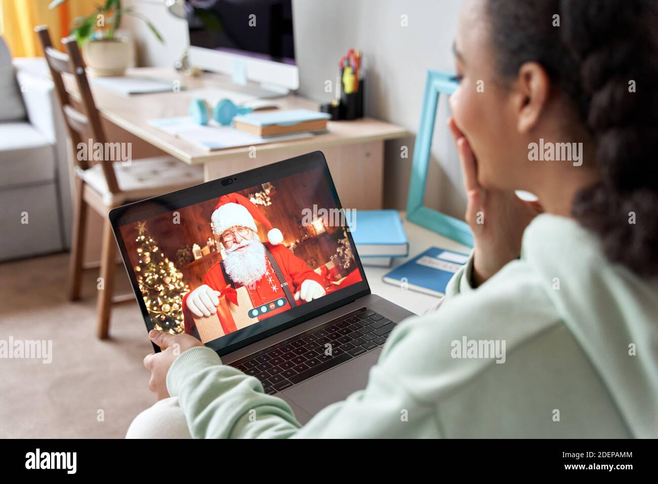 African American teen Mädchen im Gespräch mit virtuellen weihnachtsmann auf Video-Chat Online-Anruf. Stockfoto