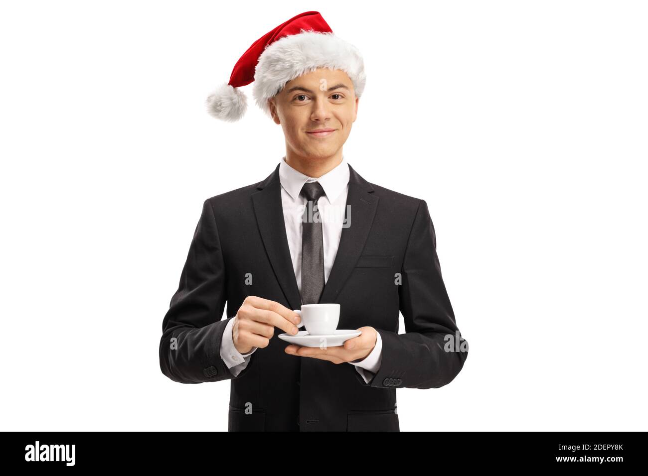 Junger Mann in einem Anzug trägt einen weihnachtsmann Hut und Halten Sie eine Espresso-Kaffeetasse isoliert auf weißem Hintergrund Stockfoto