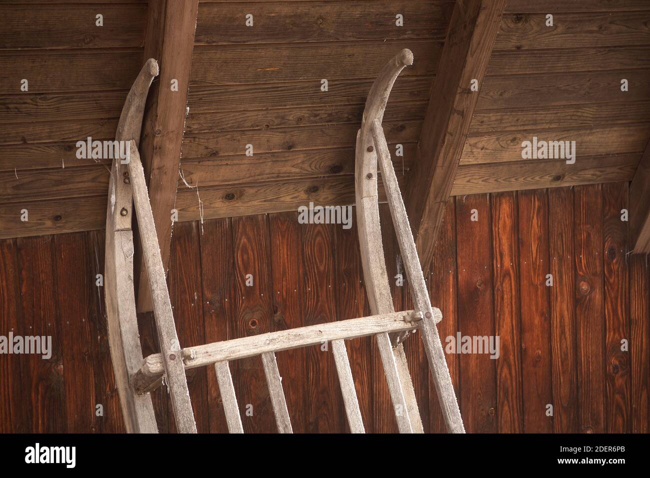 Holzschlitten aus Vintage lehnt sich an die Wand. Rustikale Scheune in den  alpen mit Retro-Schlitten Nahaufnahme Stockfotografie - Alamy