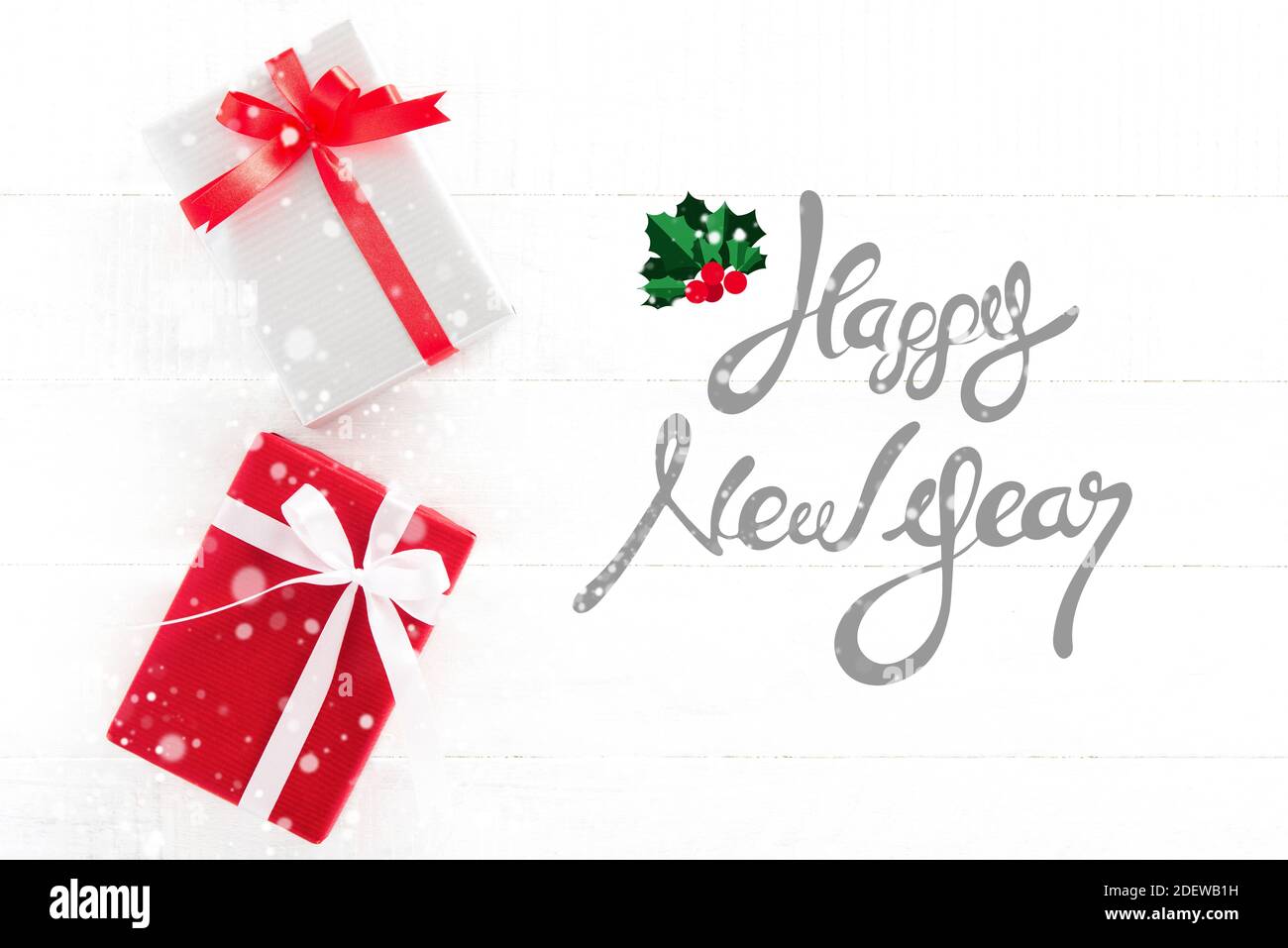 Frohes neues Jahr Text auf weißem Holz Hintergrund mit Geschenk Kisten und Schnee-Effekt Stockfoto