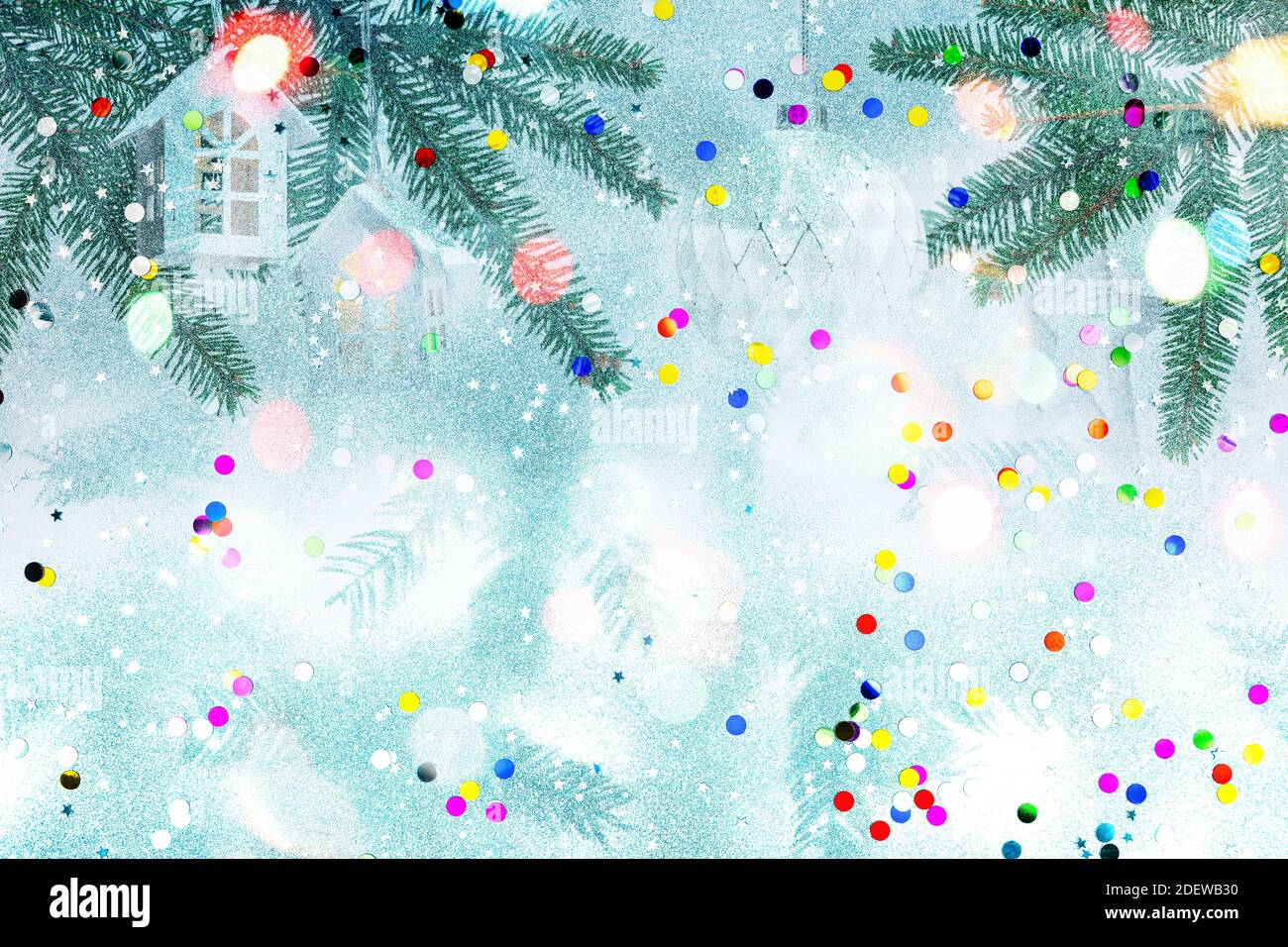 Grüne Tannenzweige geschmückt mit weihnachtsschmuck und Weihnachtsbeleuchtung vor weißem Hintergrund mit bunten Konfetti. Doppelbelichtung Stockfoto