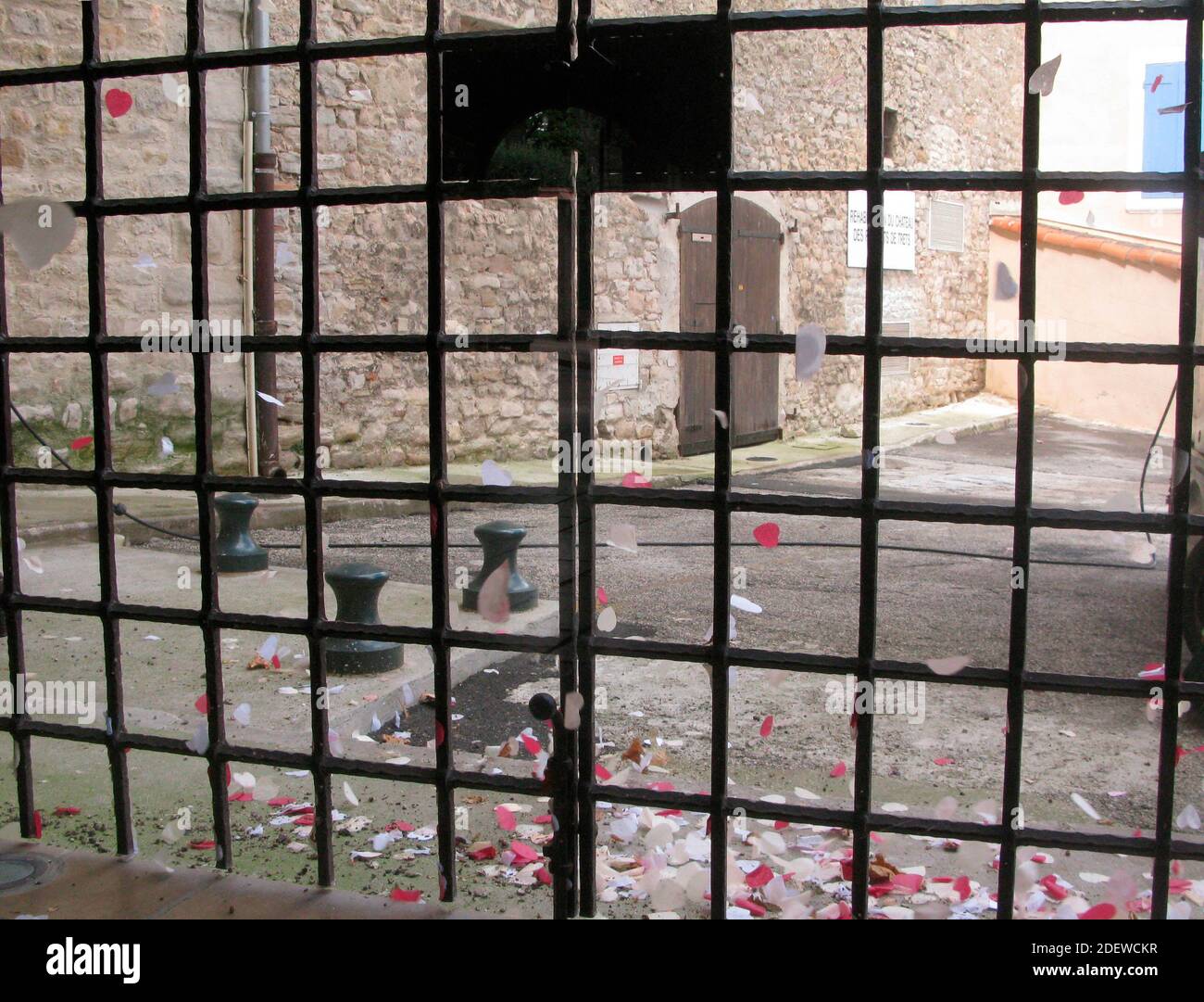 Hinter Gittern, eine Strafe in Haft, Blick auf eine Hauswand mit einer Tür Stockfoto