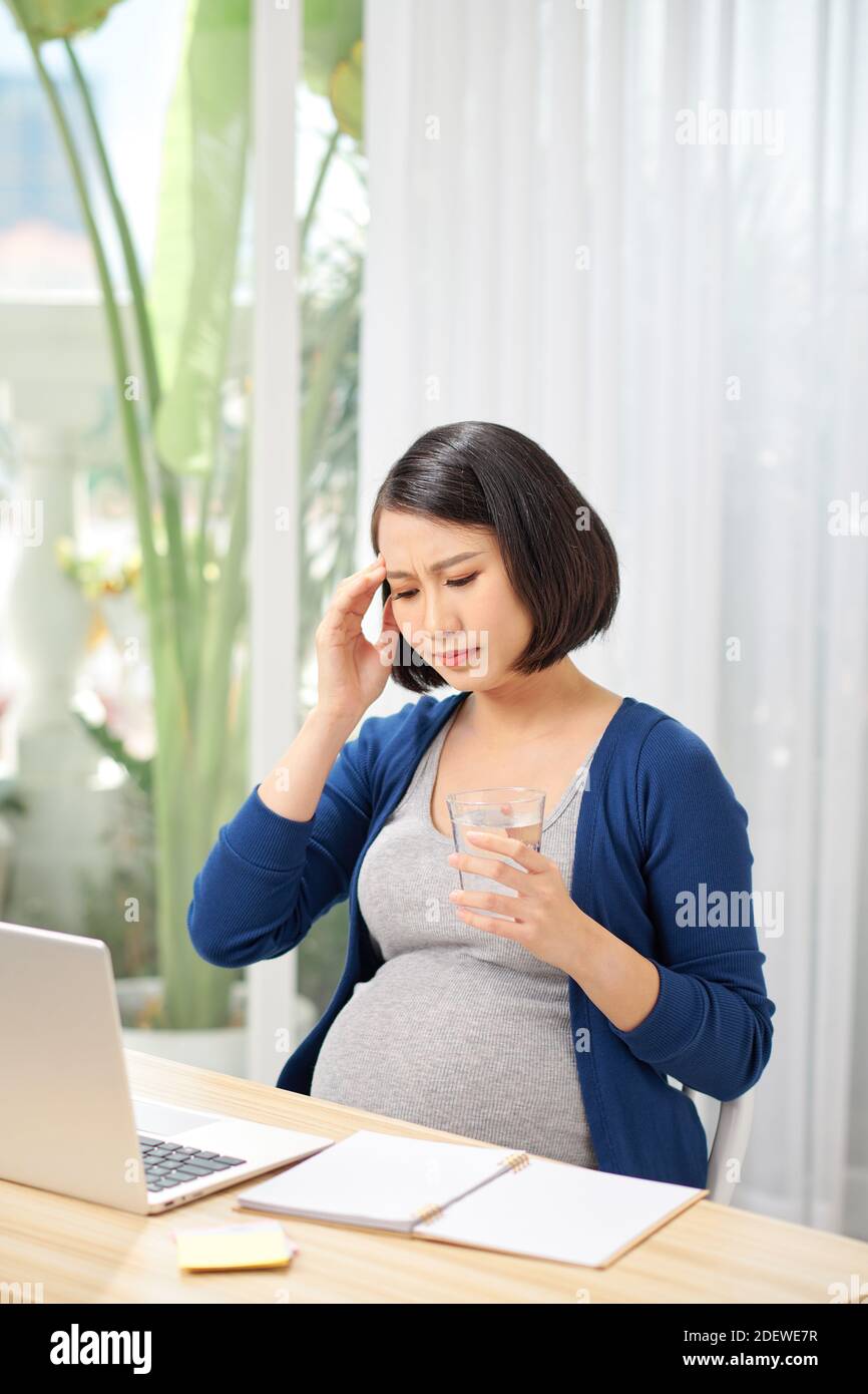 Junge schwangere Mitarbeiter im Büro Stockfoto