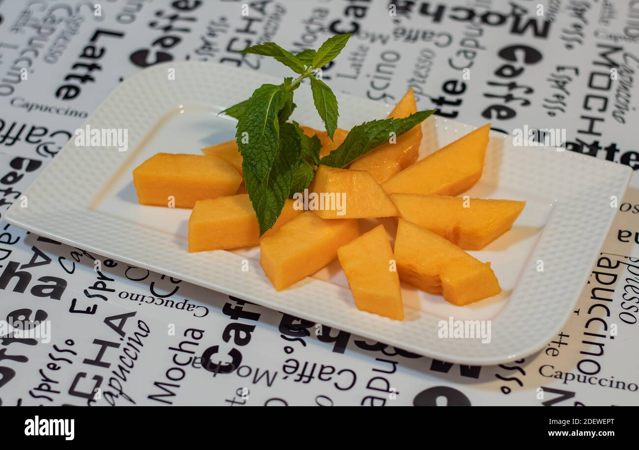 Stücke der Melone auf einem Teller. Nahaufnahme, selektiver Fokus, verschwommener Hintergrund, Konzeptfoto gesunde Ernährung. Stockfoto