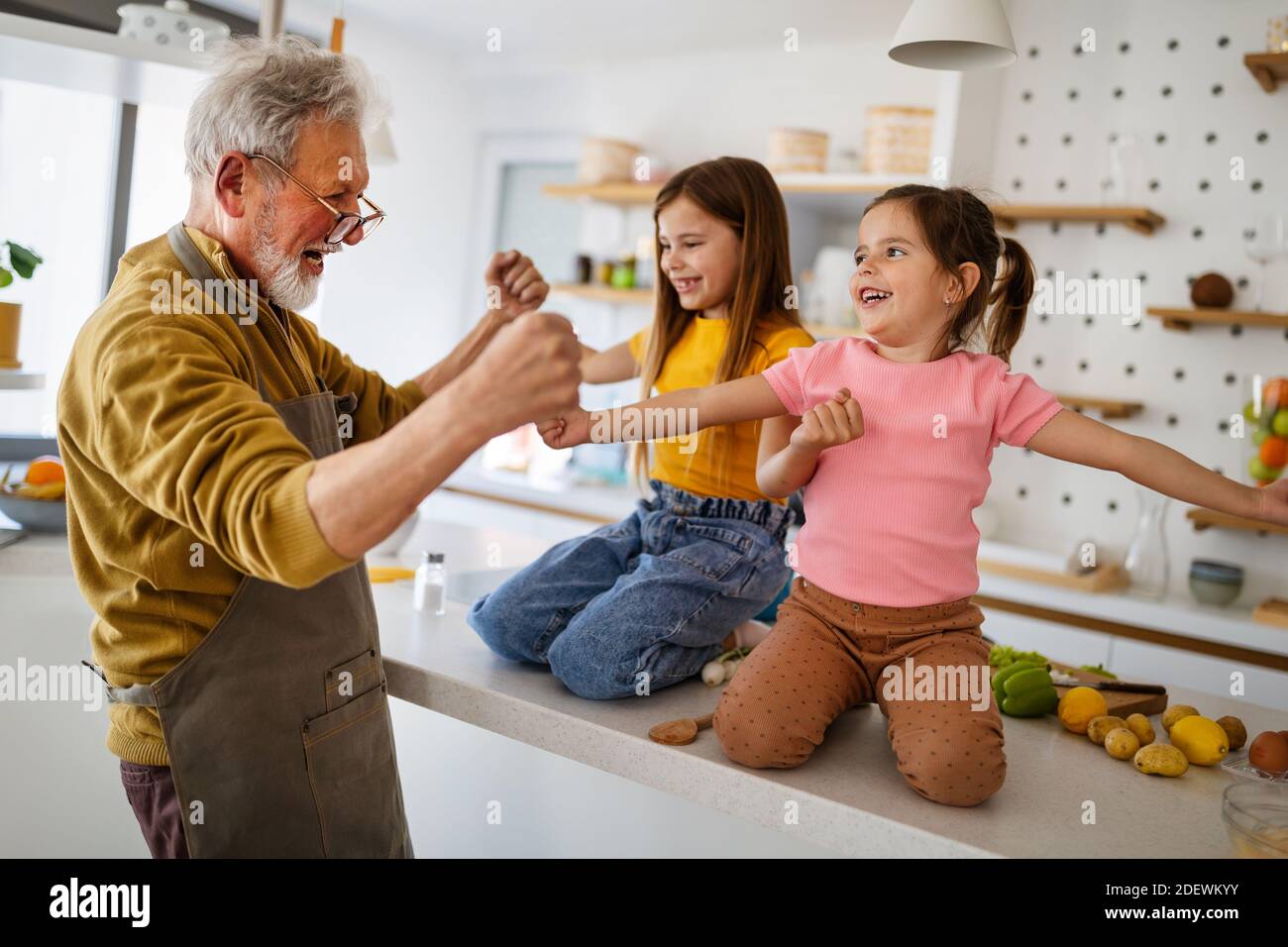 Enkelkinder, die Spaß haben, spielen mit Großeltern zu Hause Stockfoto