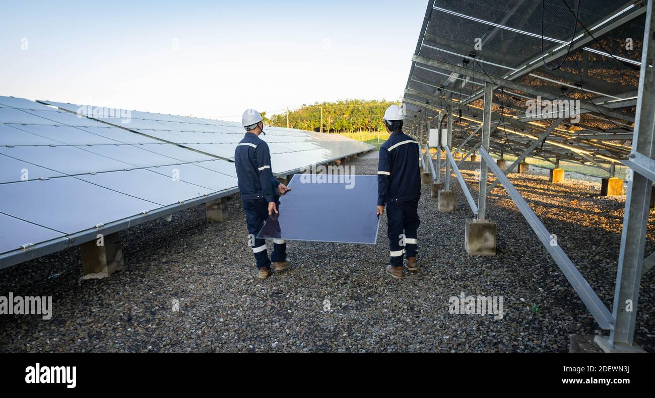 Techniker hebt die Solarzelle, um die beschädigte zu ersetzen, Alternative Energie, um die Energie der Welt zu sparen, Photovoltaikmodul Idee für sauber Stockfoto