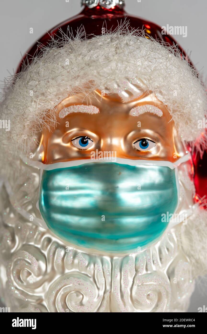 Symbolisches Bild von Weihnachten in der Corona-Krise, Vater Weihnachtsfigur, Weihnachtsmann, Weihnachtsbaum Dekorationen, mit Mund-Nase-Maske, Alltag ma Stockfoto