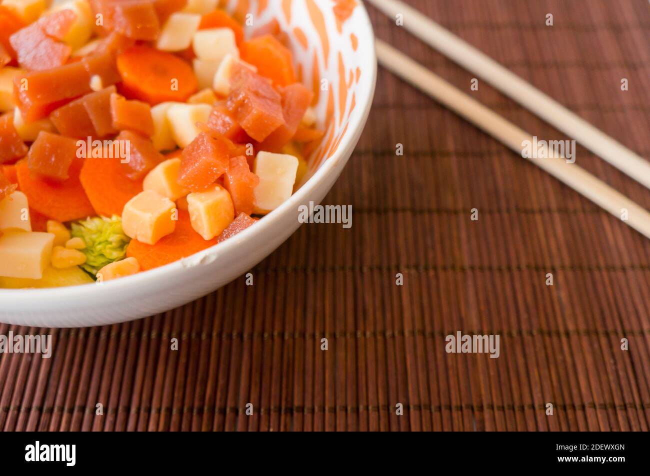 Salat mit Käse, Karotten, Salatquitte auf einer weißen Schüssel Stockfoto