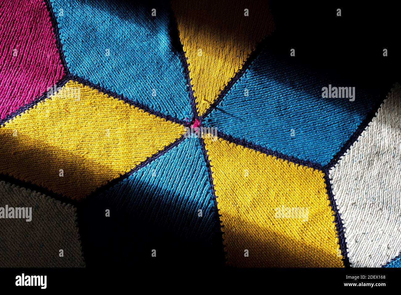 Sonnenlicht kommt auf den türkischen handgewebten Teppich. Handgewebter Teppich hat gelbe, blaue, rote und weiße Farben. Traditioneller Teppich. Stockfoto