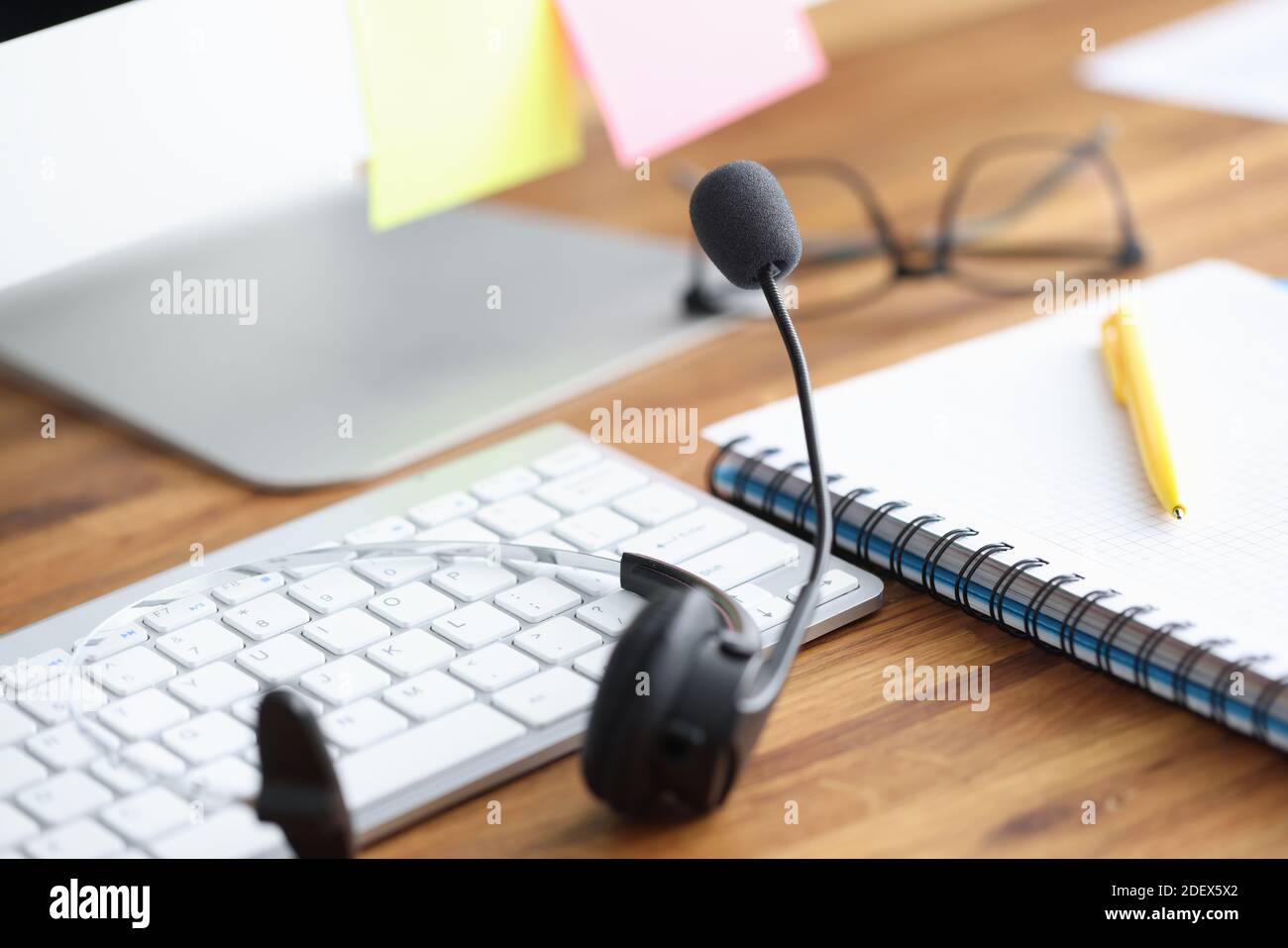 Auf dem Tisch befinden sich Kopfhörer mit Mikrofon und Tastatur, Tagebuch und Stift Stockfoto