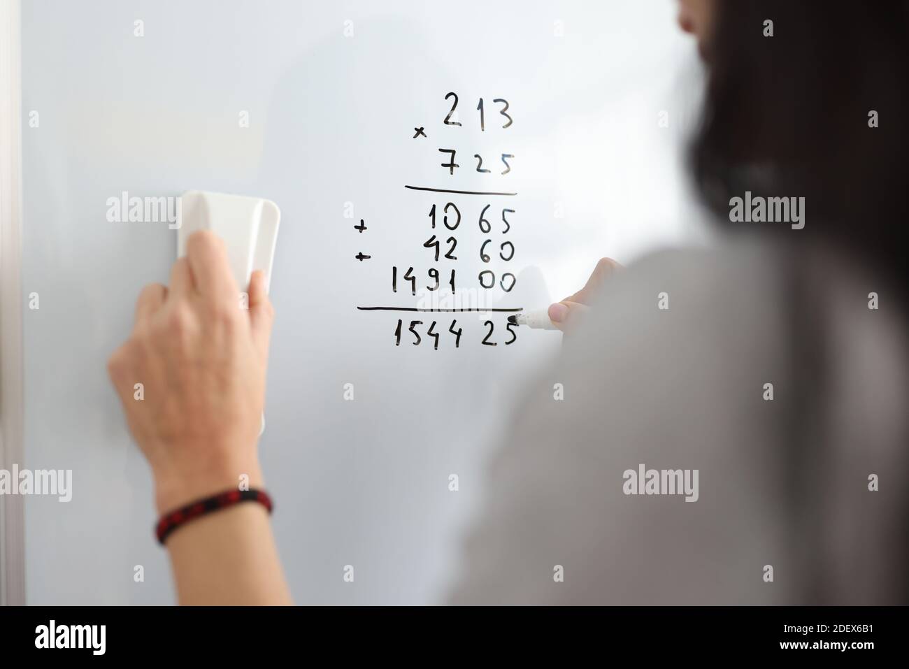 Frau auf Whiteboard fügt mathematische Zahlen hinzu Stockfoto