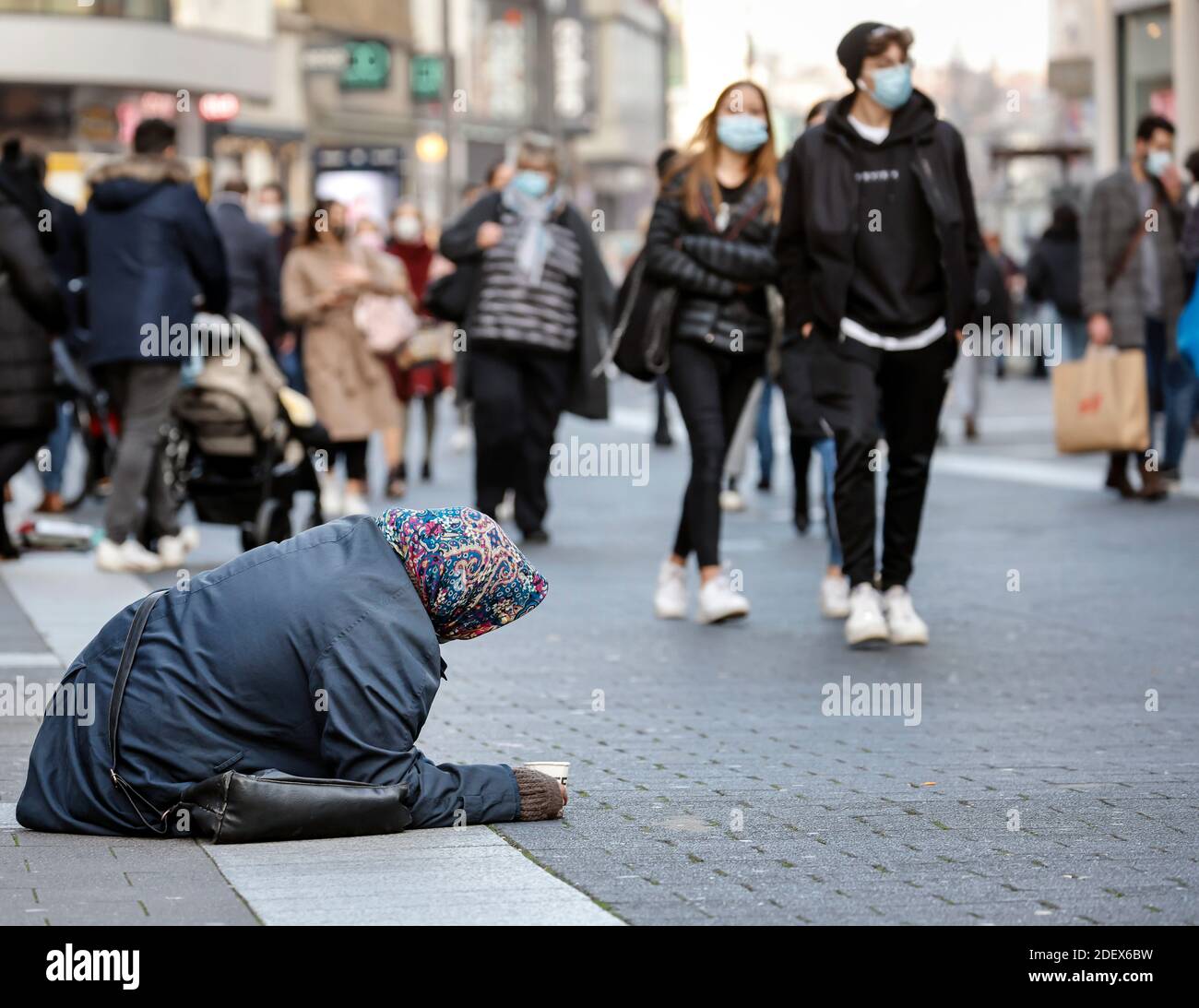 Düsseldorf, Nordrhein-Westfalen, Deutschland - Bettelfrau sitzt in der Altstadt von Düsseldorf in Zeiten der Corona-Krise im zweiten Teil l Stockfoto