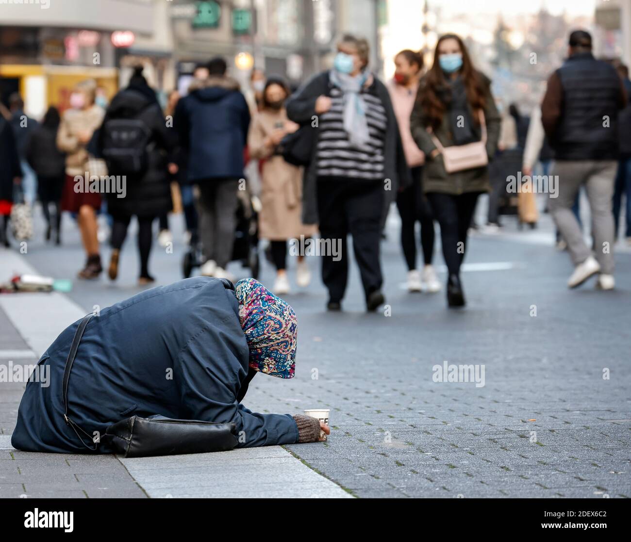 Düsseldorf, Nordrhein-Westfalen, Deutschland - Bettelfrau sitzt in der Altstadt von Düsseldorf in Zeiten der Corona-Krise im zweiten Teil l Stockfoto