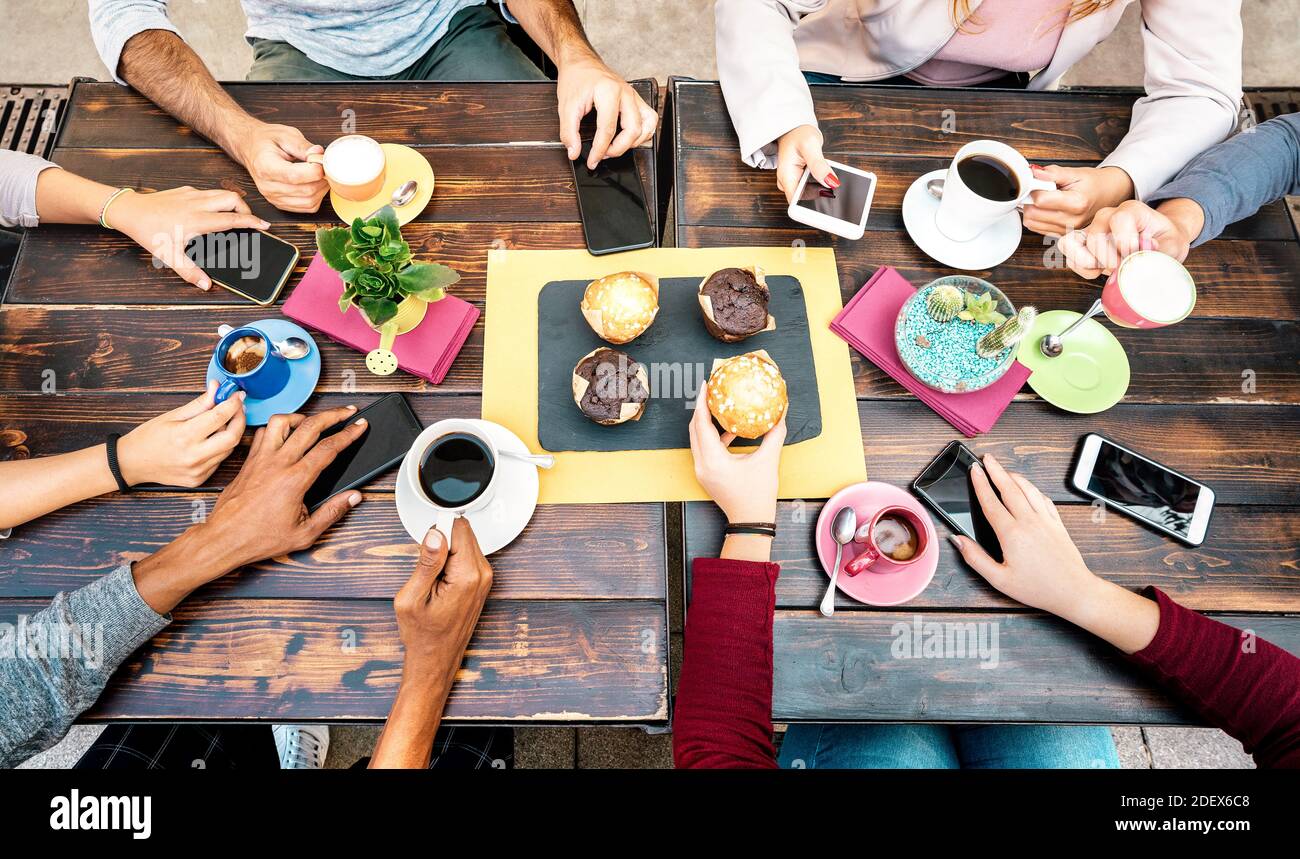 Draufsicht auf Hände mit Telefonen im Coffee Shop Restaurant - Menschen frühstücken zusammen mit mobilen Smartphones an Mode-Café-Bar Stockfoto