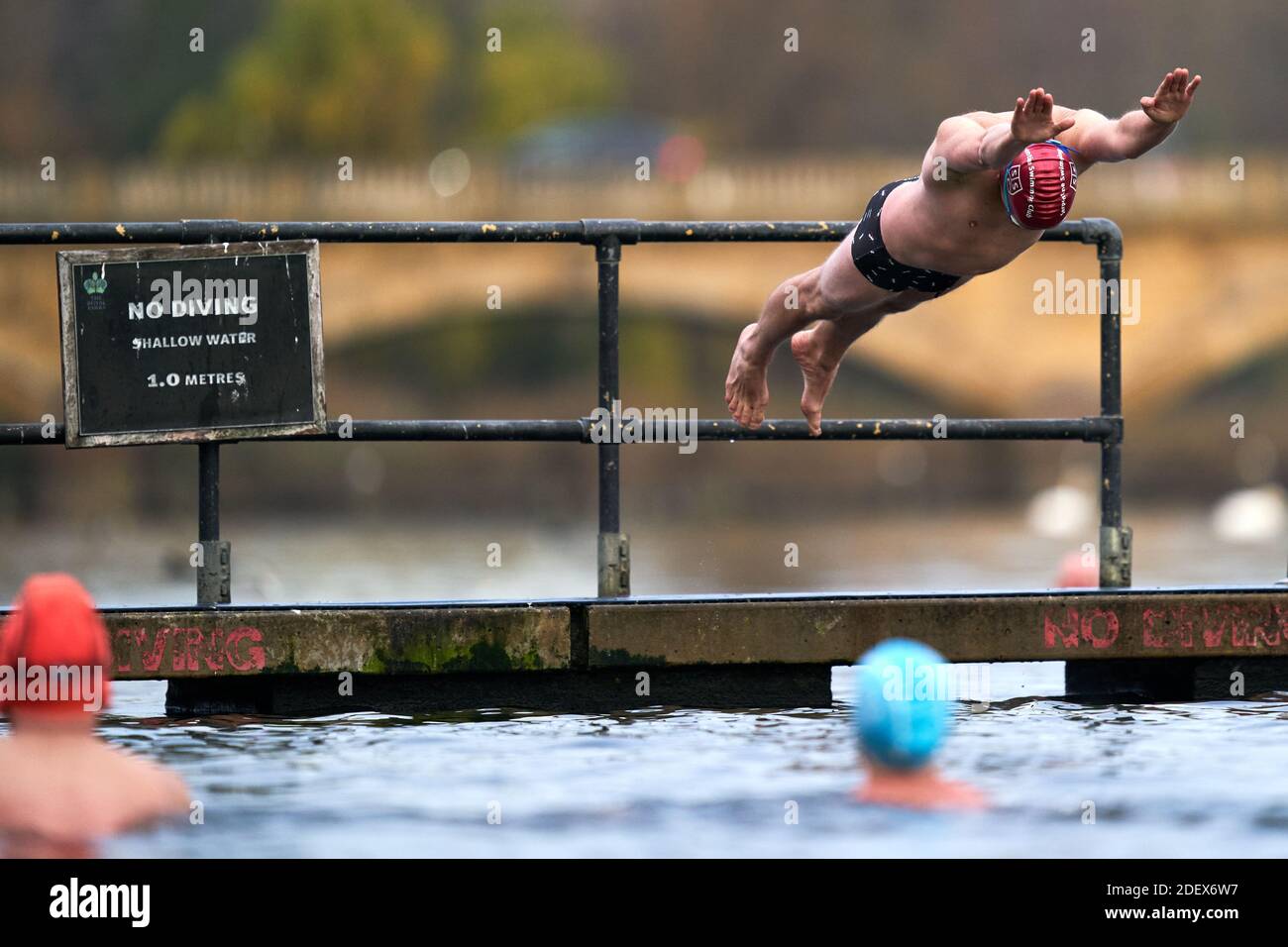 Ein Schwimmer geht ins Wasser des Serpentine Swimming Club, nachdem die zweite nationale Sperre beendet ist und England ein gestärktes, gestaffeltes System von Coronavirus-Restriktionen hat. Stockfoto