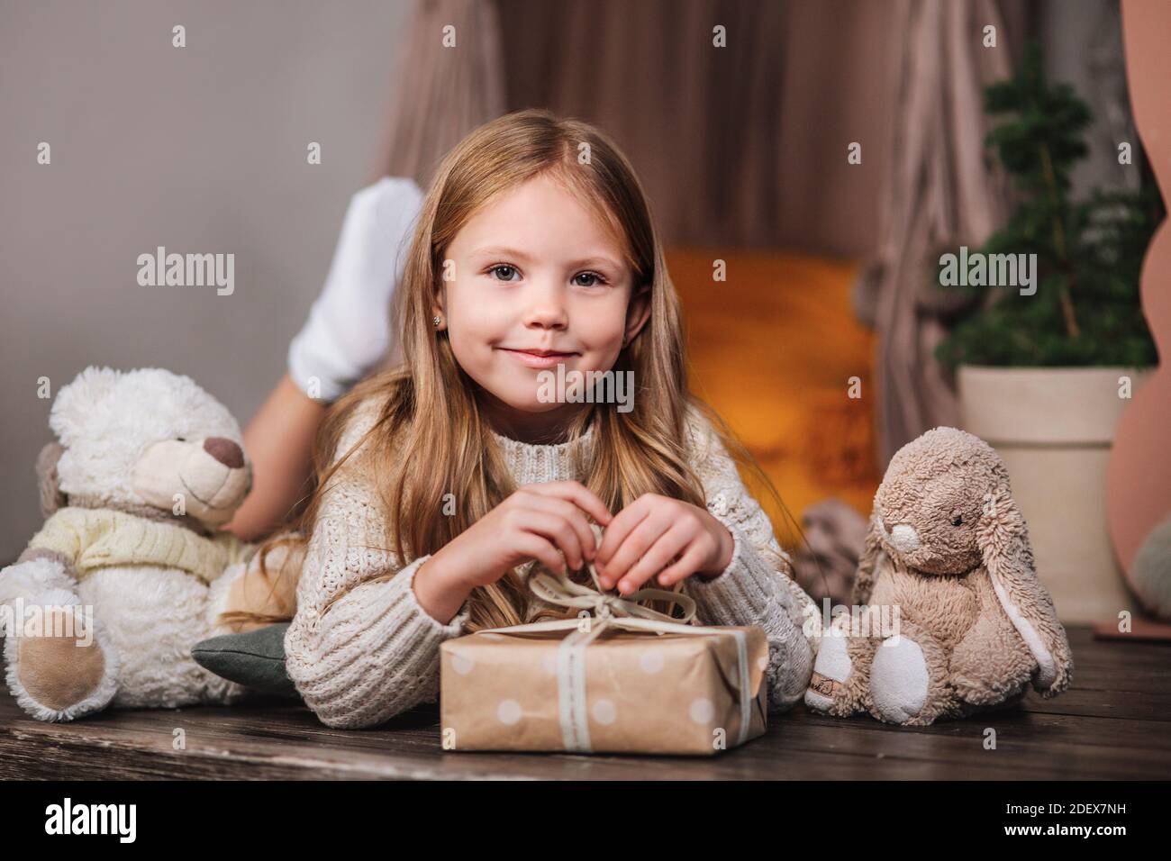 Nettes kleines Kind mit Weihnachtsgeschenkschachteln und Spielzeug Zu Hause Stockfoto