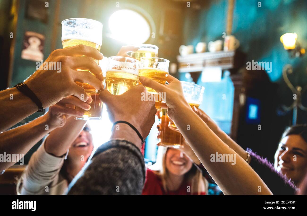 Eine Gruppe von glücklichen Freunden, die in der Brauerei Bier trinken und toasten Bar-Restaurant: Freundschaftskonzept, bei dem junge Leute Spaß haben Gemeinsam im Vintage Pub Stockfoto