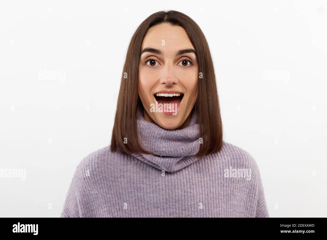 Studio Schuss lächelnd froh Frau hat ansprechende Erscheinung, lächelt breit, gekleidet lila Pullover Posen vor weißem Hintergrund drückt positiv Stockfoto