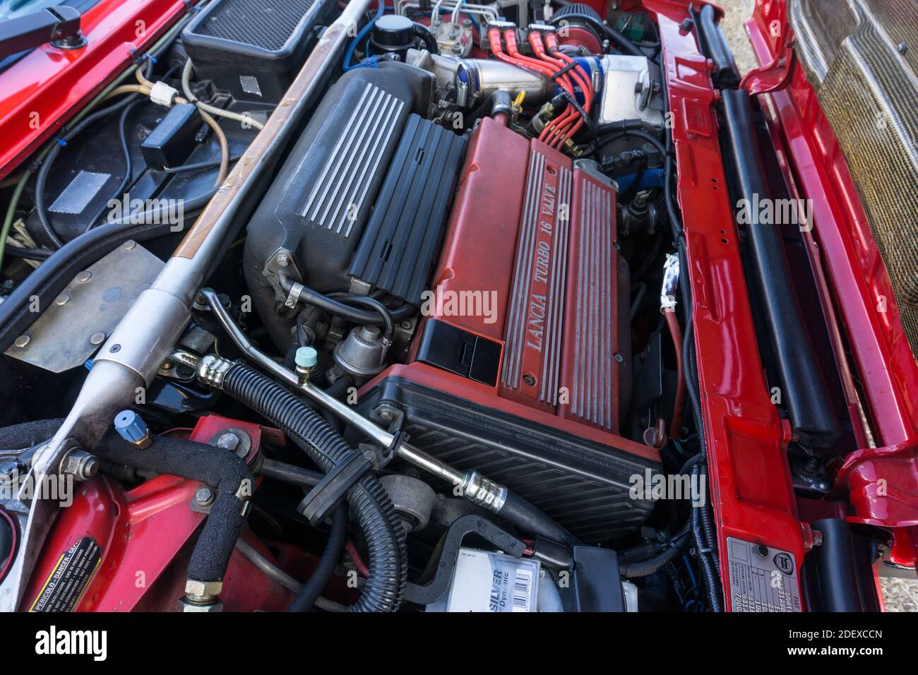 Nahaufnahme des 16-Ventil-Turbomotors mit 2-Liter-Motor in einem roten Lancia Delta HF Integrale Evoluzione, zeigt die Aluminium-Strebenstrebe. Stockfoto