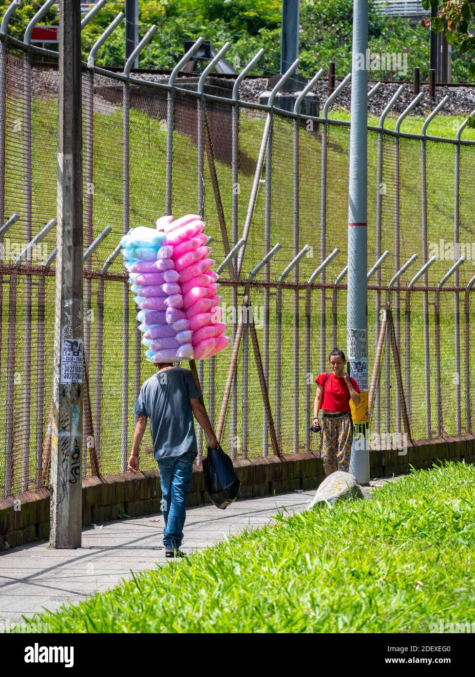 MEDELLIN, KOLUMBIEN - 16. Nov 2020: Medellin, Antioquia / Kolumbien - 15 2020. November: Verkäufer zu Fuß in einem Park mit rosa, hellblau und lila Baumwolle Stockfoto