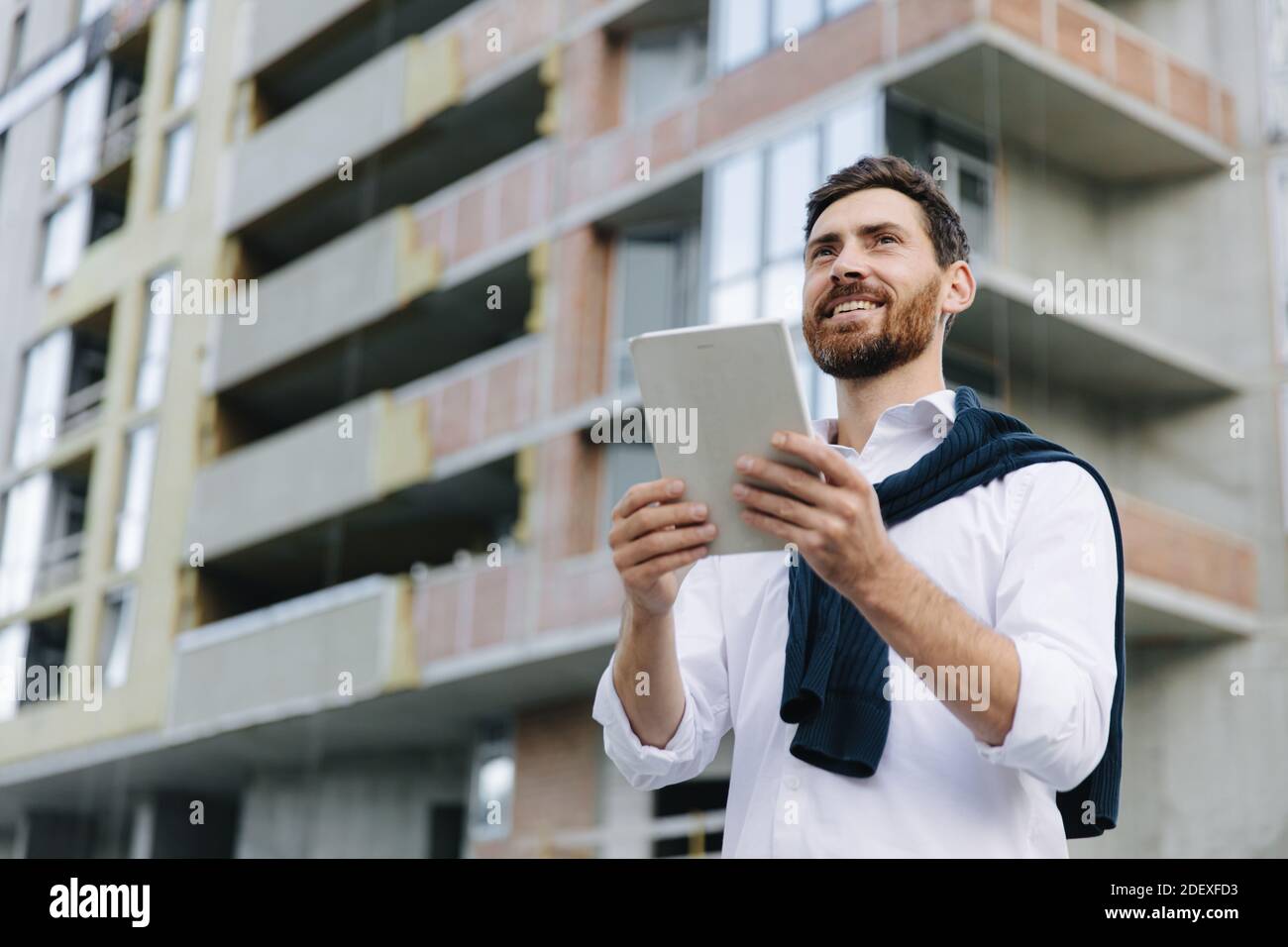 Ingenieur, der ein Tablet zum Vergleich des Bauprojekts verwendet Stockfoto