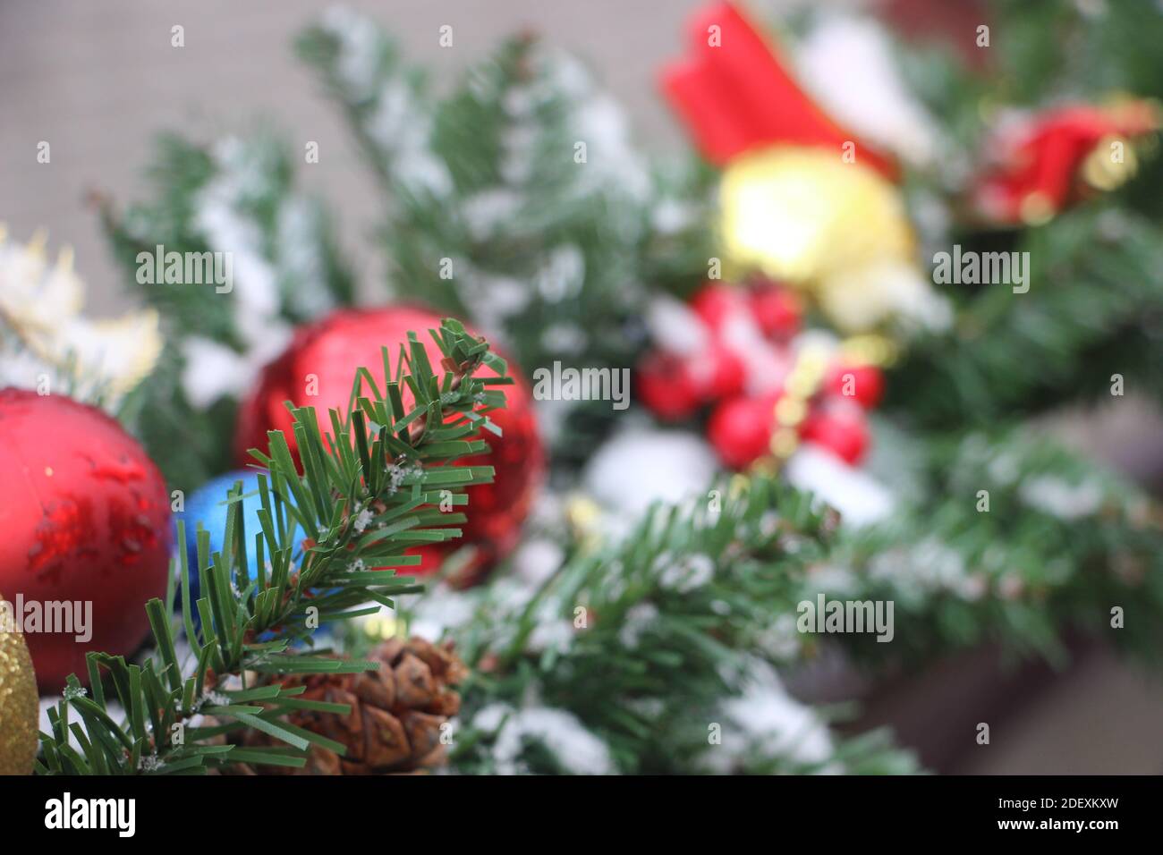 Weihnachtsschmuck auf den Zweigen der Tanne. Rote, goldene und blaue Weihnachtskugeln. Stockfoto