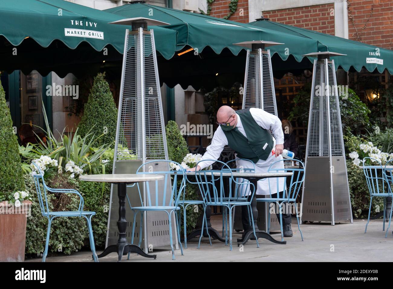 London, England. 02 Dezember 2020. Ein Kellner putzt Tische vor dem Ivy Restaurant in Covent Garden in Großbritannien (Foto: Sam Mellish / Alamy Live News) Stockfoto