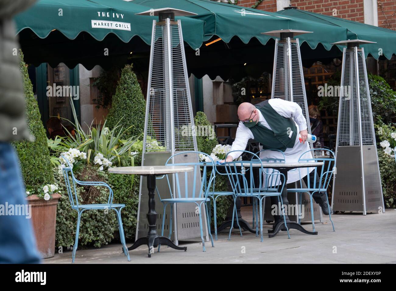 London, England. 02 Dezember 2020. Ein Kellner putzt Tische vor dem Ivy Restaurant in Covent Garden in Großbritannien (Foto: Sam Mellish / Alamy Live News) Stockfoto