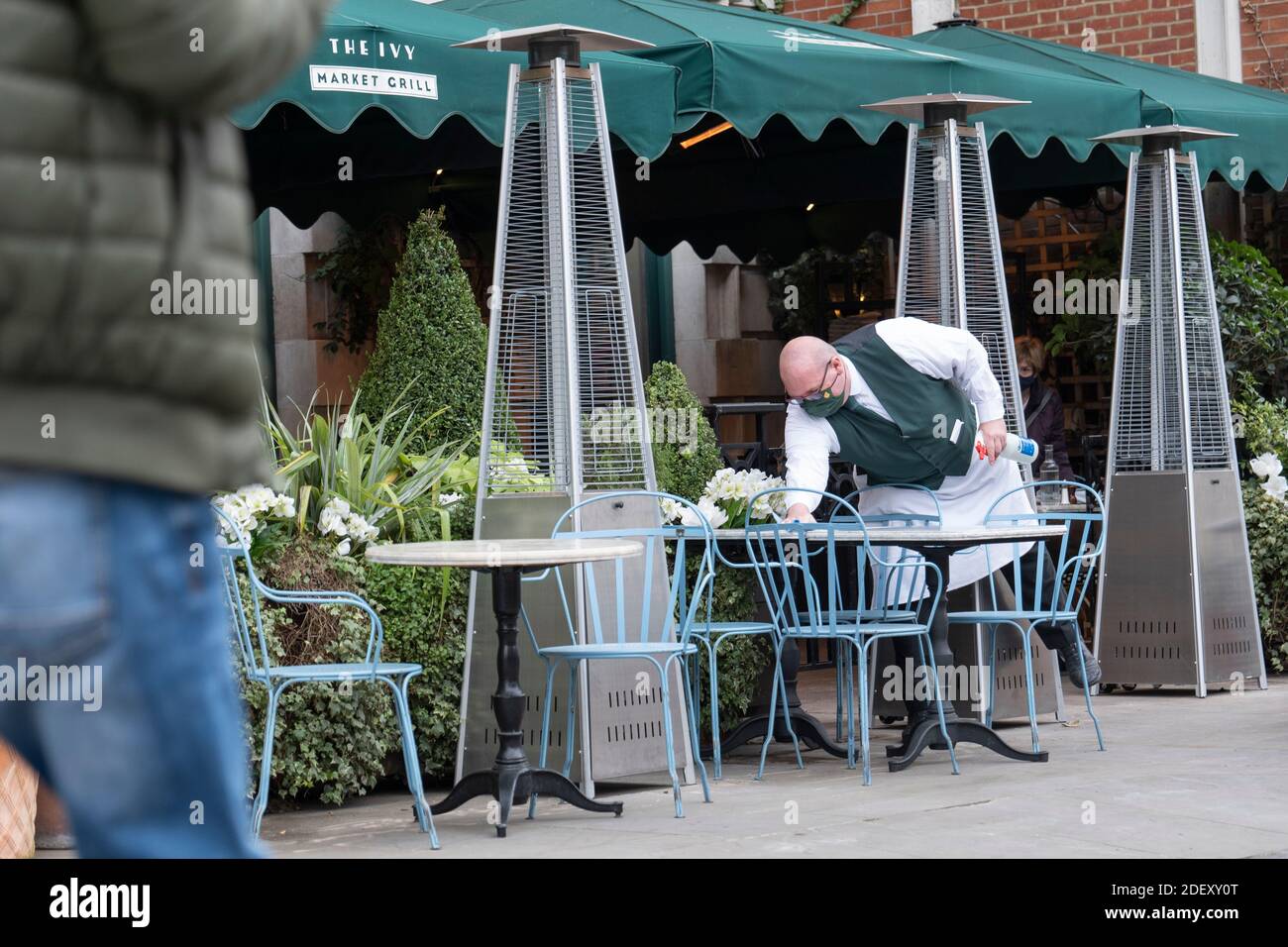 London, England. 02 Dezember 2020. Ein Kellner putzt Tische vor dem Ivy Restaurant in Covent Garden in Großbritannien (Foto: Sam Mellish / Alamy Live News) Stockfoto