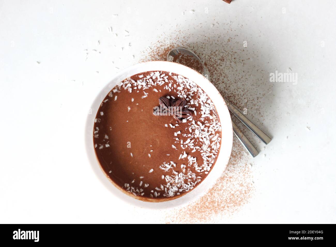 Schokoladen-Bananenmousse mit Kokosnuss-Topping auf weißem Hintergrund. Stockfoto