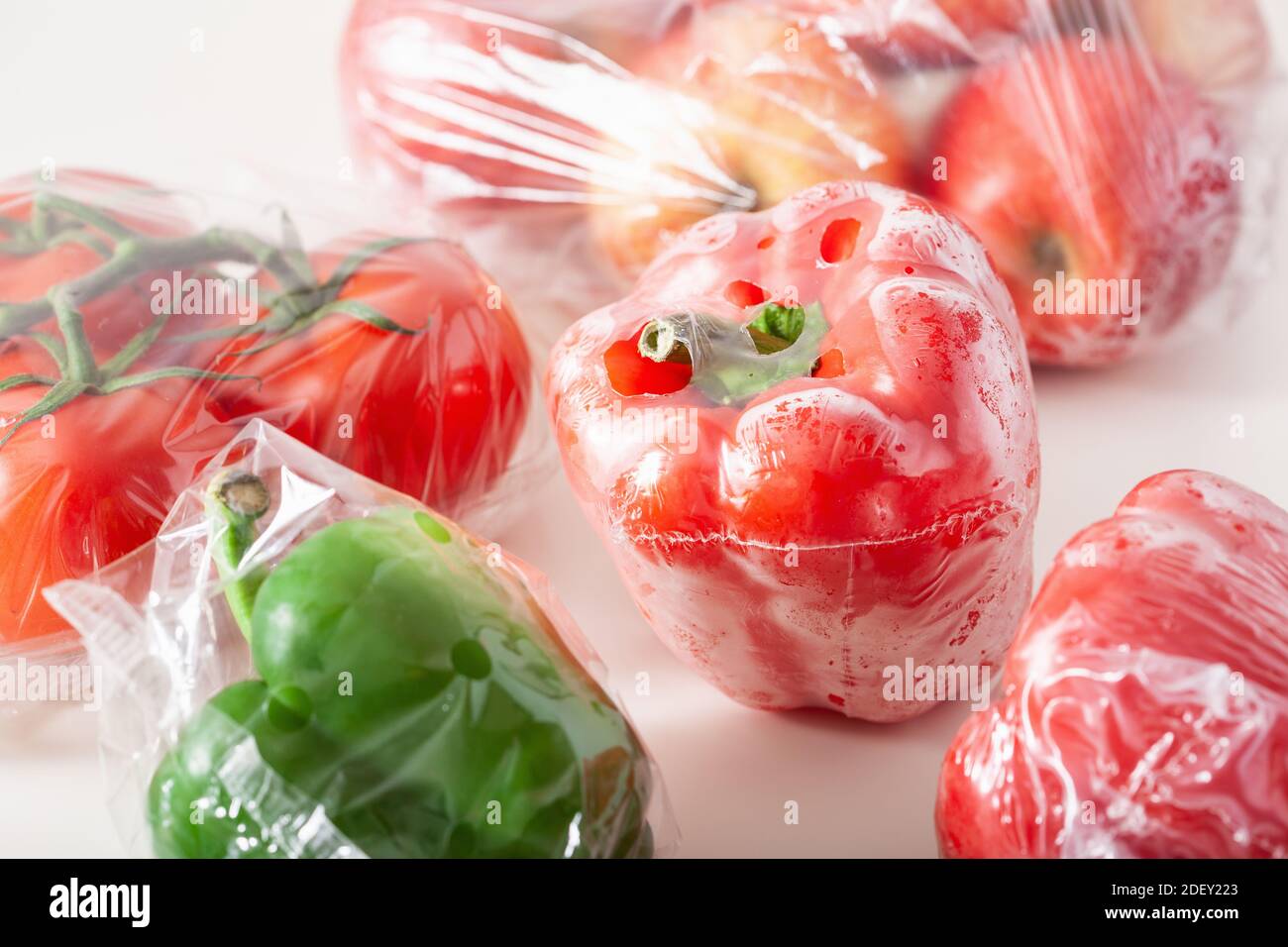 Single use Kunststoffverpackungen. Peperoni Tomaten äpfel Gemüse in Plastiktüten Stockfoto