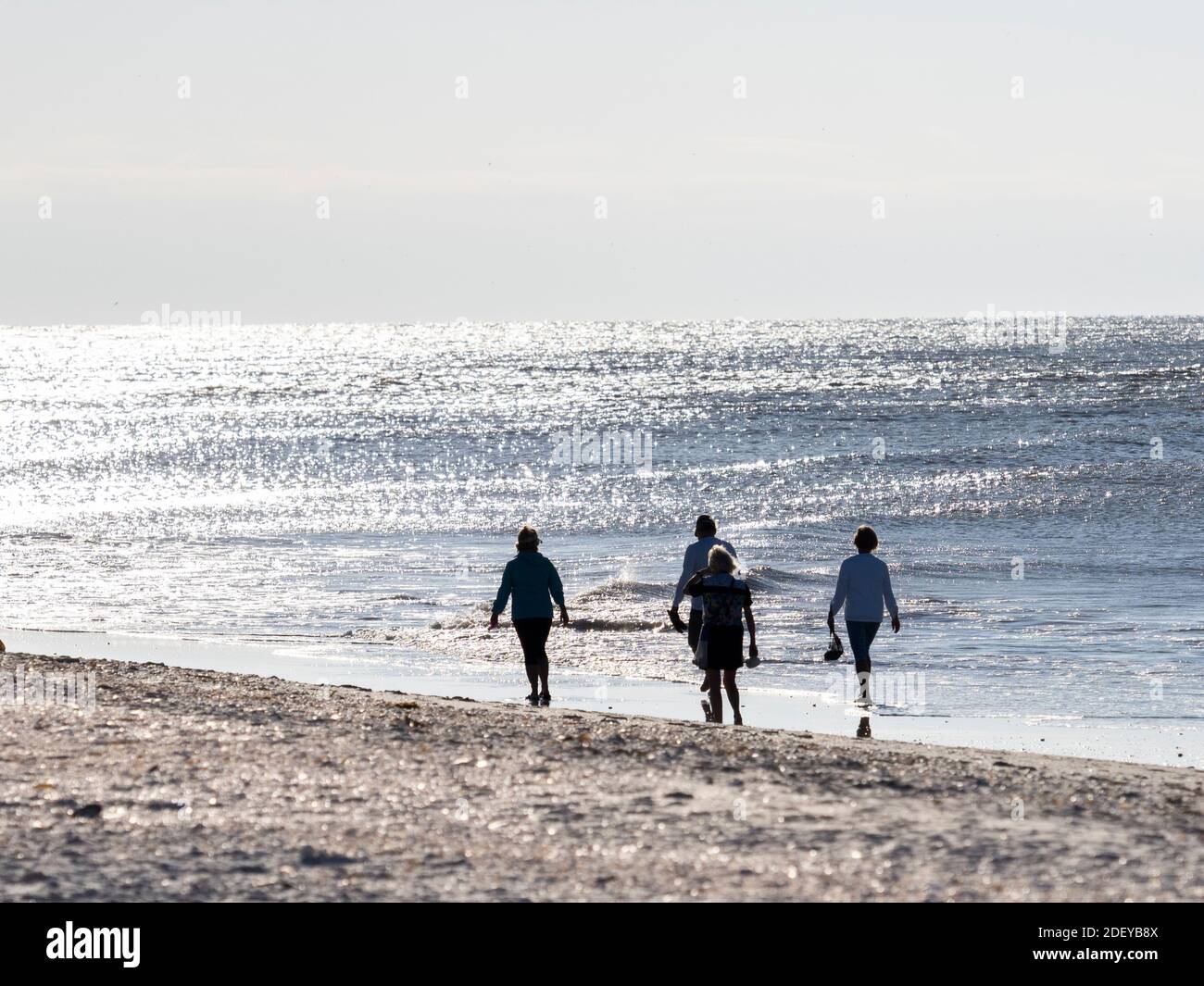 Menschen, die am Strand des Golfs von Mexiko auf Sanibel Island spazieren gehen Florida in den Vereinigten Staaten Stockfoto