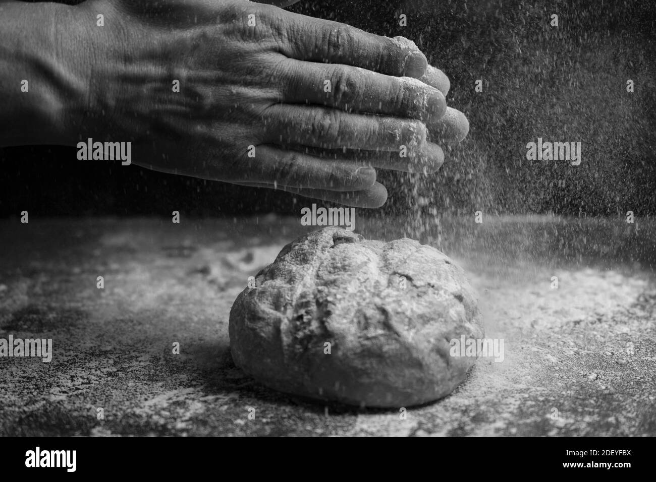 Brot fliegen mit Mehl Splash auf mehligen Hintergrund.Kreatives Konzept der Bäckerei, Backen und Kochen.Schwarz und weiße Farben. Stockfoto