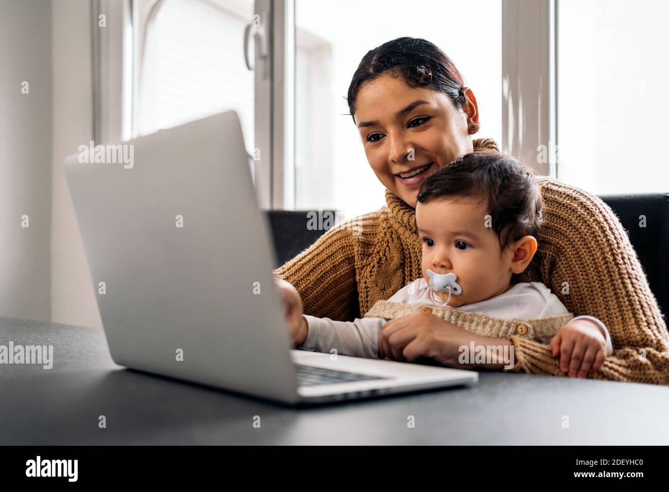 Stock Foto von glücklicher Mutter und ihr Baby beobachten Cartoons im Computer zu Hause. Stockfoto