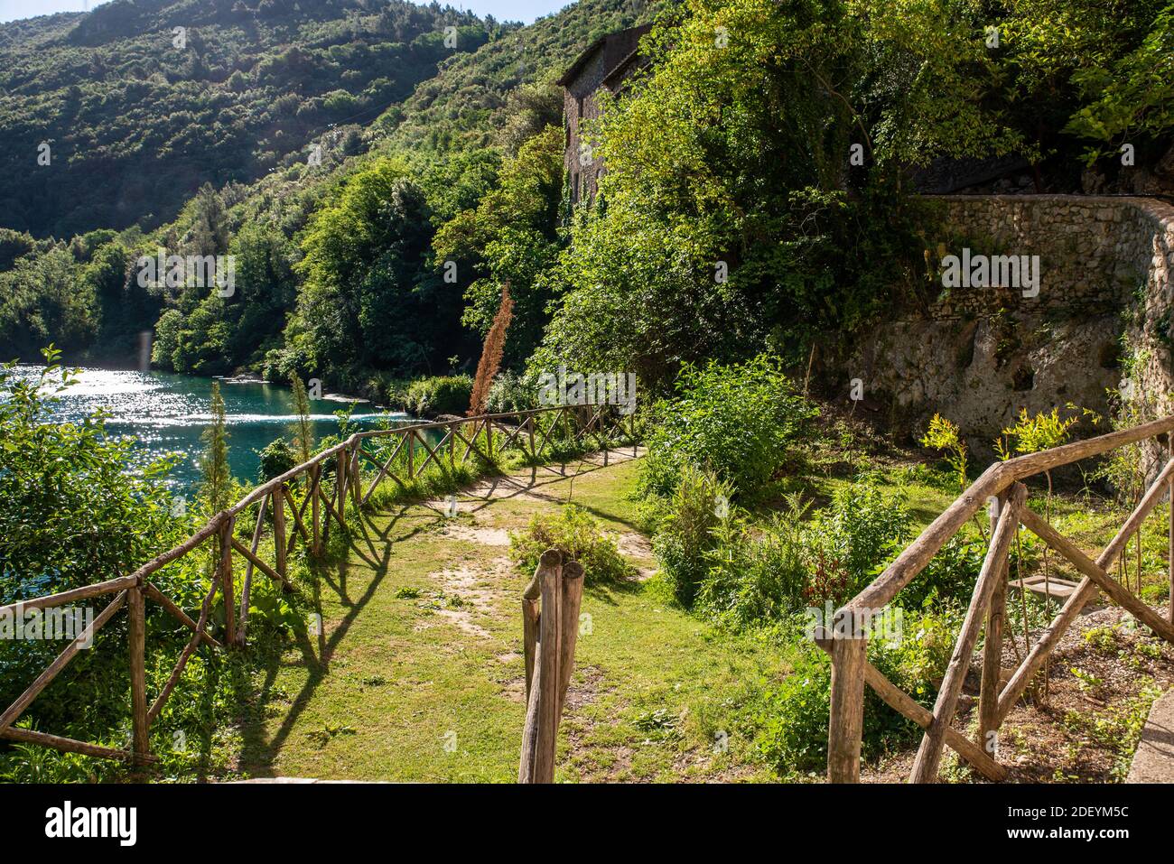 Kleiner Garten am Fluss mit blauem Wasser Stockfoto