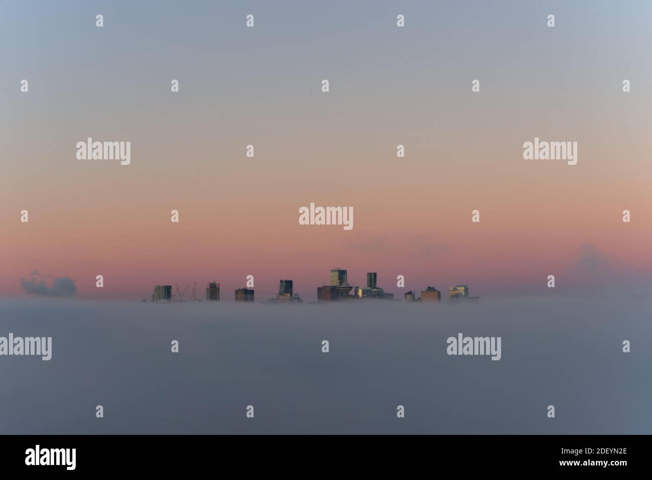 Stadt in den Wolken, Paradise City, City of Angels, Vancouver City Wolkenkratzer über dem Nebel mit der Morgensonne, die einen reflektierenden falschen Sonnenuntergang erzeugen Stockfoto