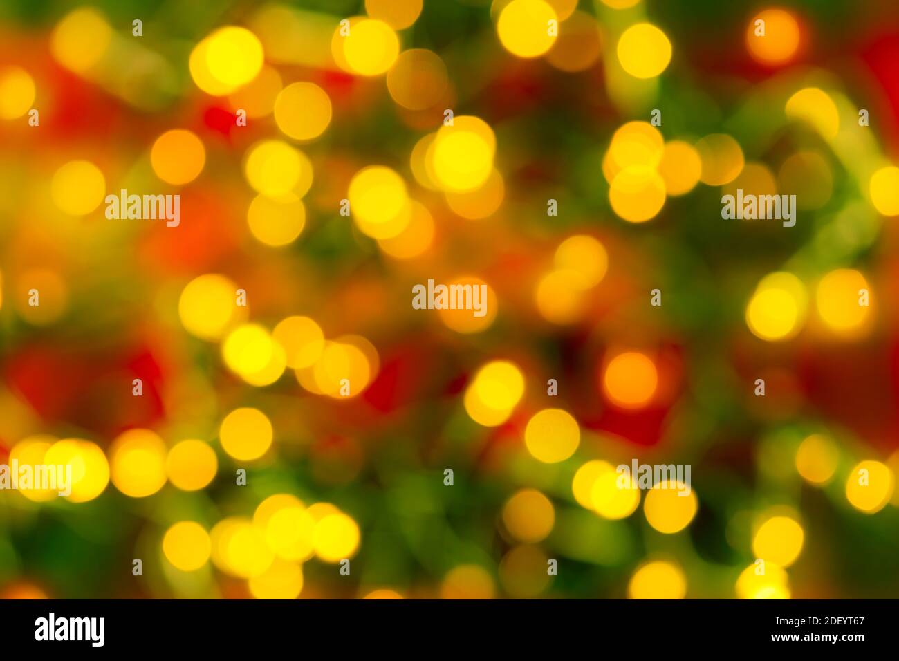 Bokeh gelb LED Beleuchtung auf einem verschwommenen rot-grünen Hintergrund. Defokussierung Lichter einer elektrischen Girlande. Dekoration und Design-Element für den Urlaub. Stockfoto