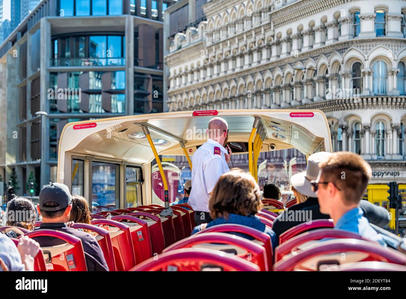 London, Großbritannien - 22. Juni 2018: Innenstadt und pov der Spitze des Big Bus Doppeldecker mit Führer Mann auf Mikrofon und Touristen sitti sprechen Stockfoto