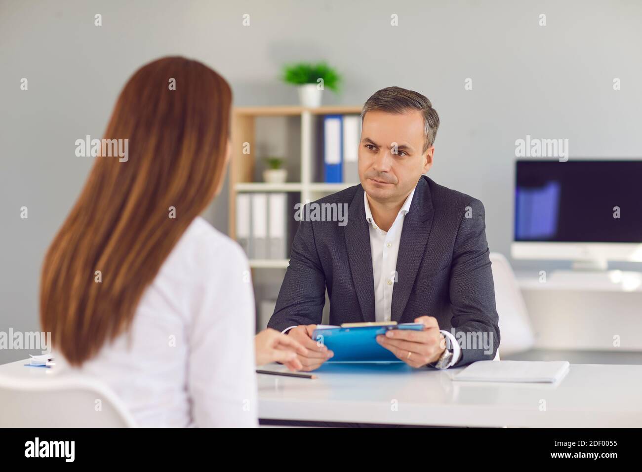 Der männliche HR-Manager führt ein Interview mit einer Kandidatin, die eine Stelle bekommt. Stockfoto