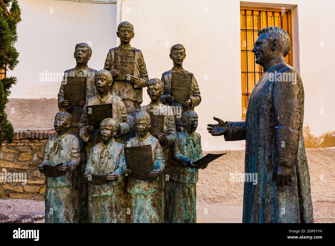 Gruppenstatue des Escolanía de Guadix mit einem Priester davor. Dieses Bronzesemble, das Werk von Elisa Merino, wurde anlässlich der Fft Stockfoto