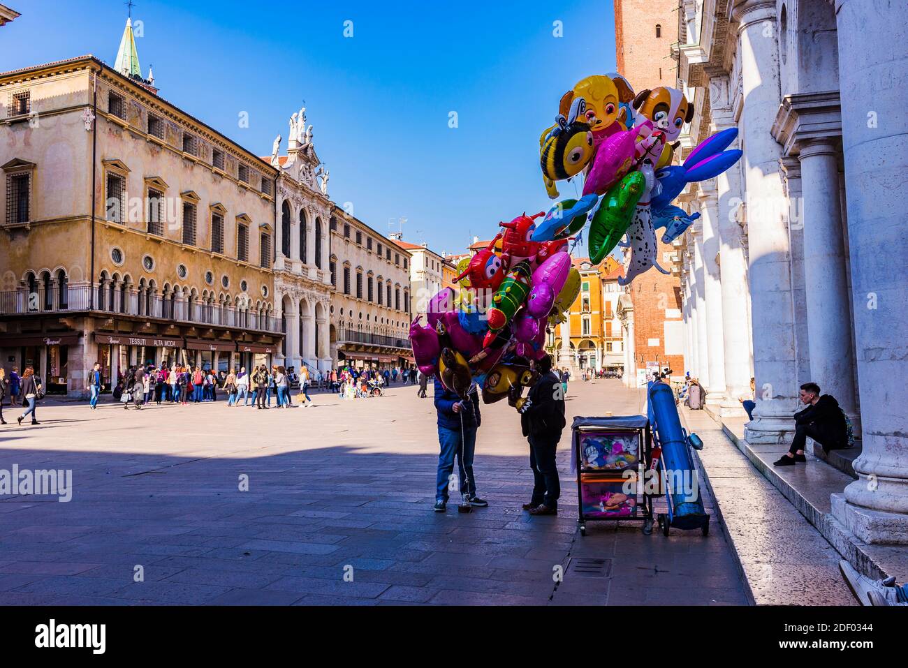 Ein Mann verkauft Ballons vor Palazzo del Monte di Pieta auf der Piazza dei Signori mit Fassade der Kirche von San Vincenzo. Vicenza, Venetien, Italien, Europa Stockfoto