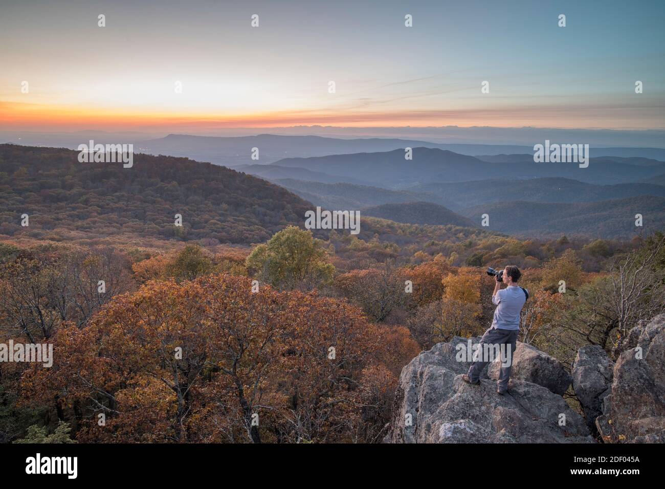 Ein Mann macht ein Foto bei Sonnenuntergang im Herbst am Bearfence Mountain im Shenandoah National Park, Virginia. Stockfoto