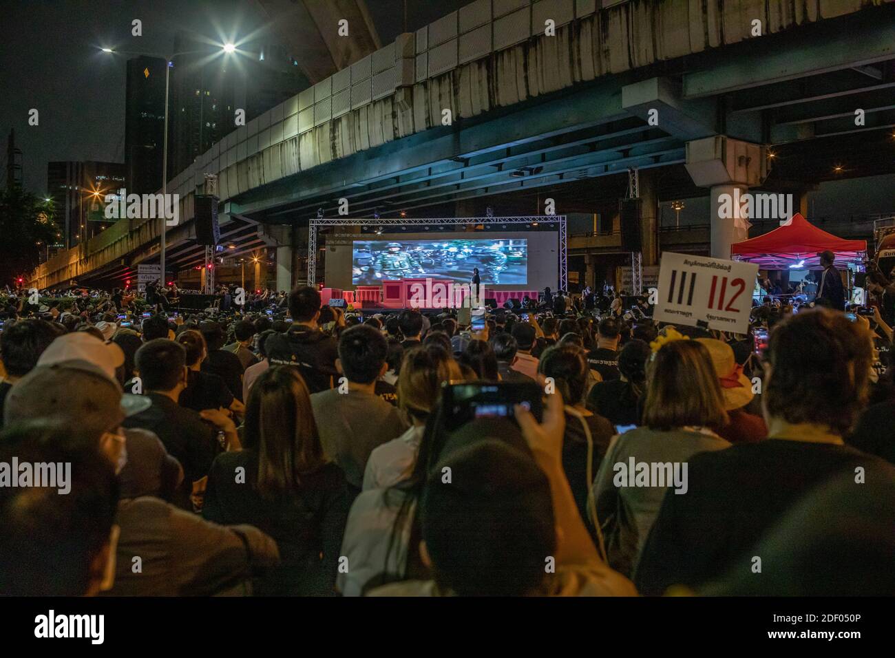 Prodemokratische Demonstranten hören der Aktivistin Panusaya "rung" Sithijirawattanakul zu, während sie einen Film über den Konflikt zwischen der thailändischen Armee und den Roten Hemden ansahen.2010 kamen 99 Menschen während einer regierungsfeindlichen Demonstration in der thailändischen Hauptstadt ums Leben. Tausende von prodemokratischen Demonstranten versammelten sich an der Kreuzung von Lad Phrao, um den Rücktritt des thailändischen Premierministers Prayut Chan-o-cha und die Reform der Monarchie zu fordern. Das Protestthema war die Tatsache, dass Ministerpräsident Prayut Chan-o-cha vom Gericht nicht für schuldig befunden wurde, nach seiner Pensionierung als Armee im Armeehaus zu bleiben Stockfoto