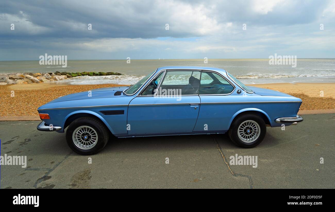 Classic Blue BMW Motor Car an der Strandpromenade mit Strand und Meer im Hintergrund geparkt. Stockfoto
