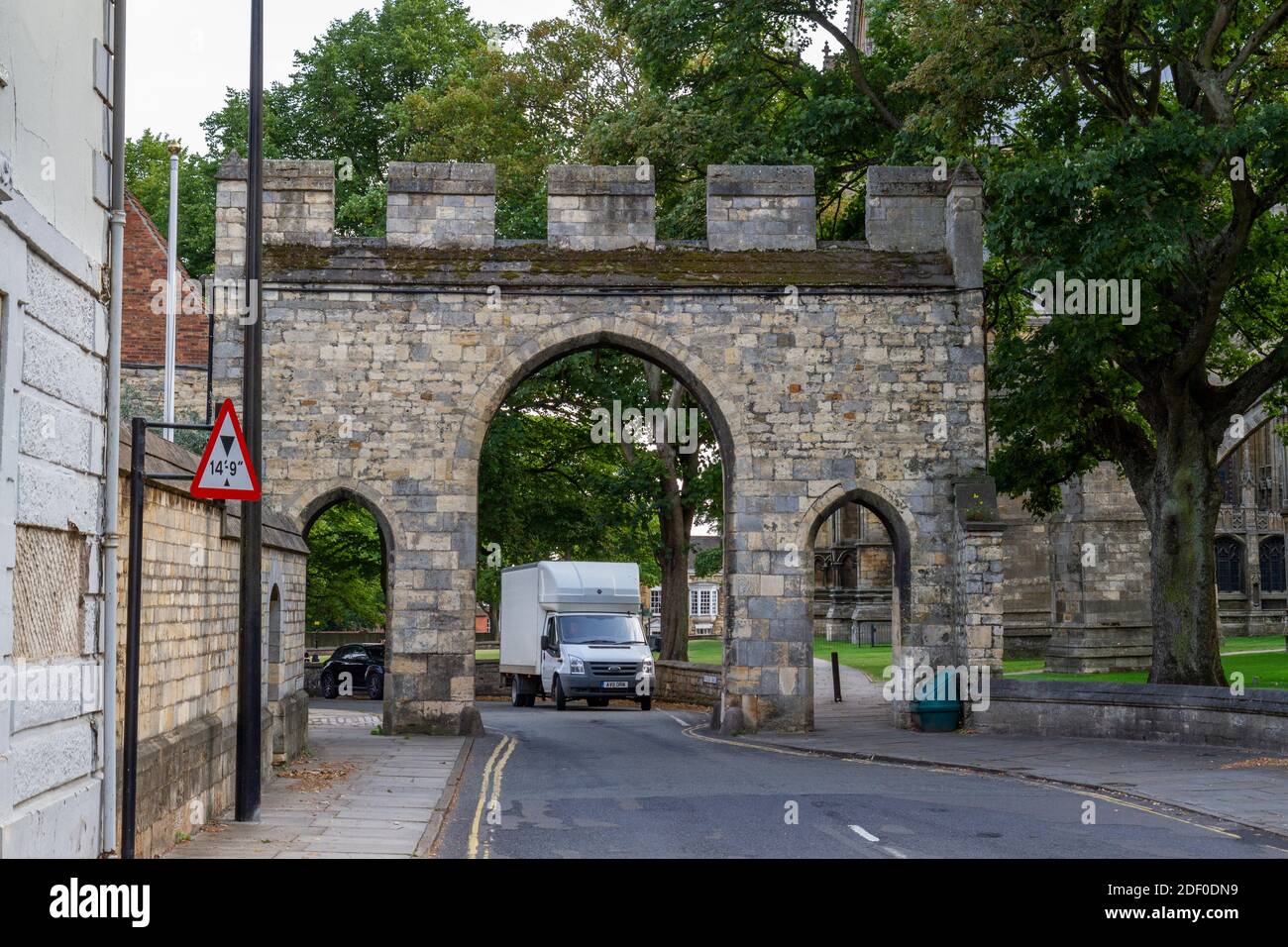 Priory Arch, ein denkmalgeschütztes Tor mit einem zentralen Spitzbogen, flankiert von einem Paar kleiner Fußgängerbögen neben der Lincoln Cathedral, Lincs, Großbritannien. Stockfoto