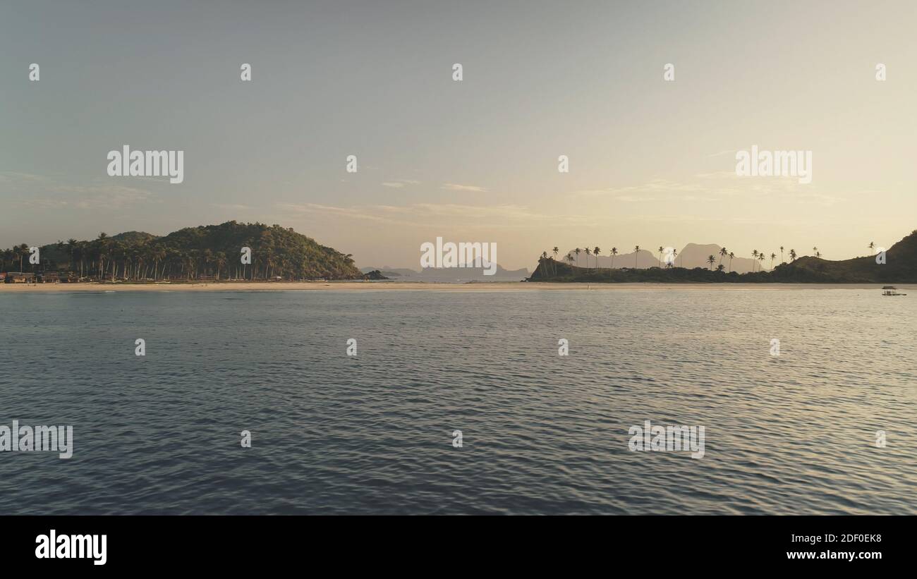 Niemand Seestück der Berge mit grünem Tropenwald an der Sandstrandantenne. Ocean Bay mit sandiger Küste und Palmen auf Hügeln. Philippinen paradiesische Inseln von El Nido. Drohnenaufnahme im Kino Stockfoto