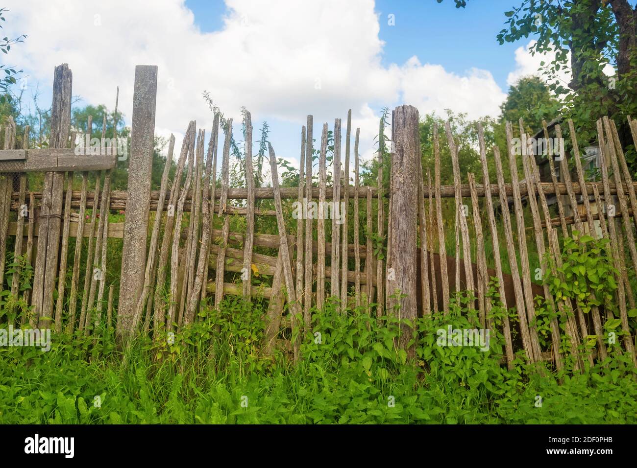 Alte klapprige Holzzaun aus schmalen Brettern vor Des Dorfhauses Stockfoto