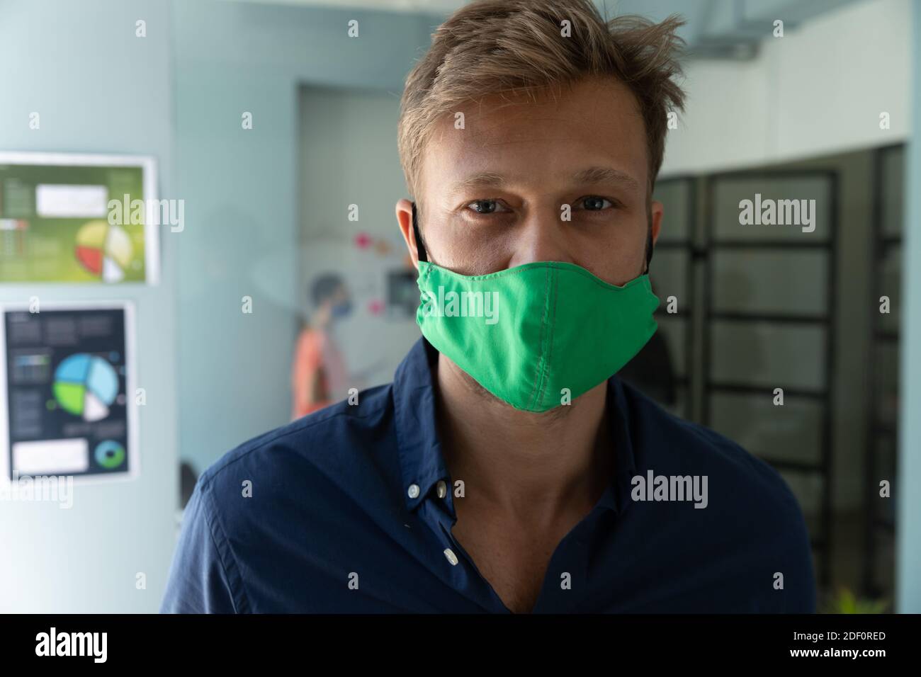 Porträt eines kaukasischen Mannes mit Maske in einem Büro Stockfoto